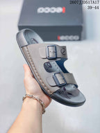 Angled view of the taupe-gray ECCO sandal highlighting its two buckle straps, open toe and dark outsole.