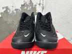 Front view of black lace-up sneakers with white toe Swooshes and perforated toe areas.