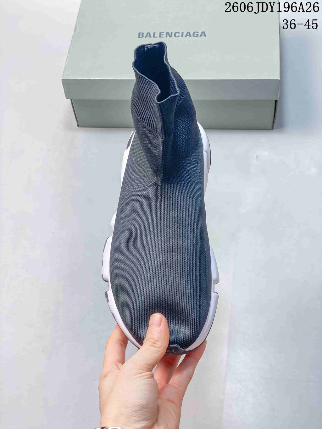 Top view of a dark gray sock-style sneaker showing the seamless-looking knit upper and high ankle collar.