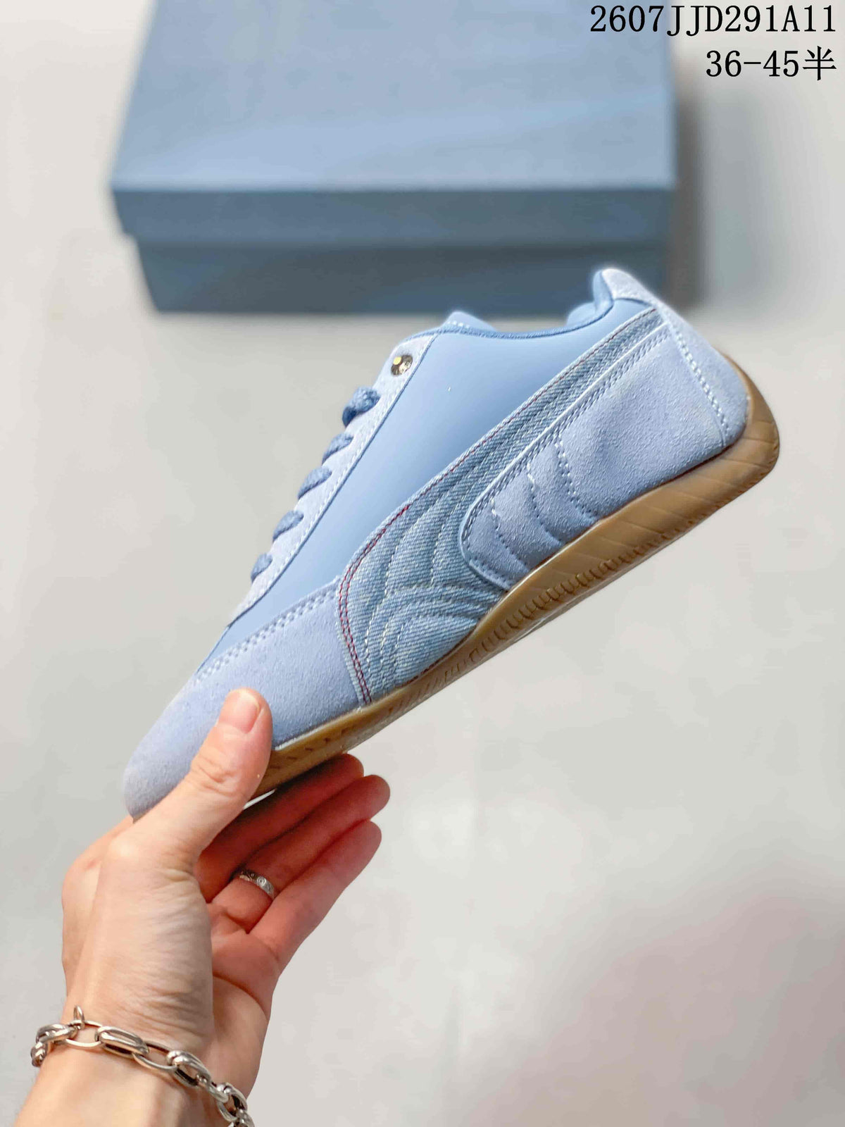 Side profile of the light blue sneaker showing the contrasting side stripe, stitching, and gum-colored sole.