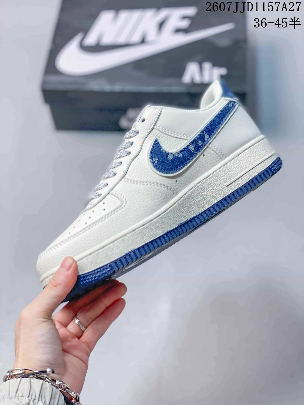 Side profile showing the white low-top construction, blue side accent, white midsole, and blue outsole.