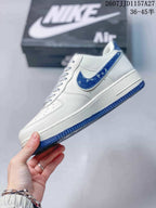 Side profile showing the white low-top construction, blue side accent, white midsole, and blue outsole.