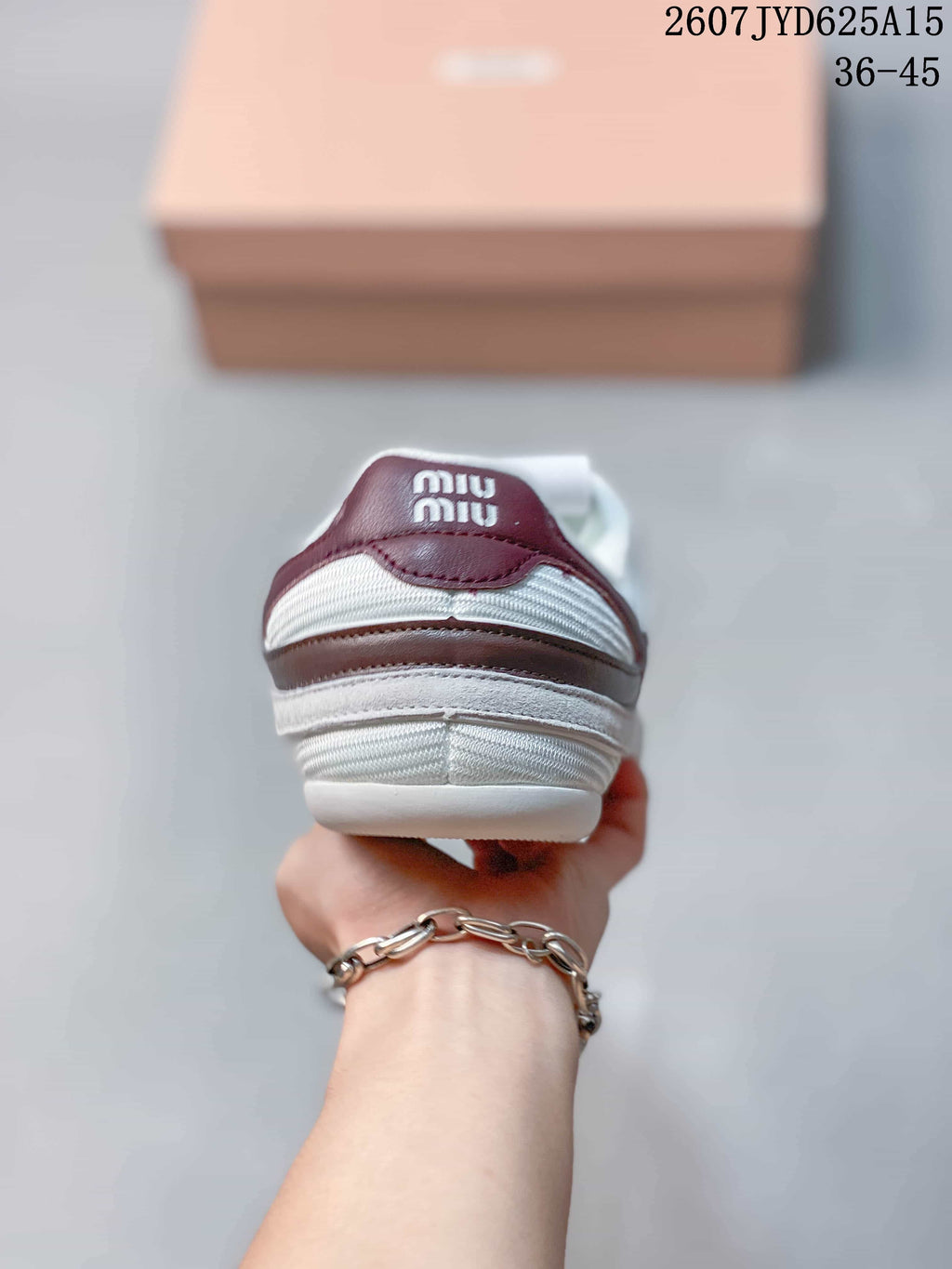Rear view of the sneaker showing burgundy heel accents, white padded collar, and Miu Miu branding on the heel tab.