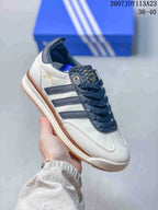 White adidas SL 72 sneaker with navy overlays and laces, dark side stripes and a gum-look outsole.