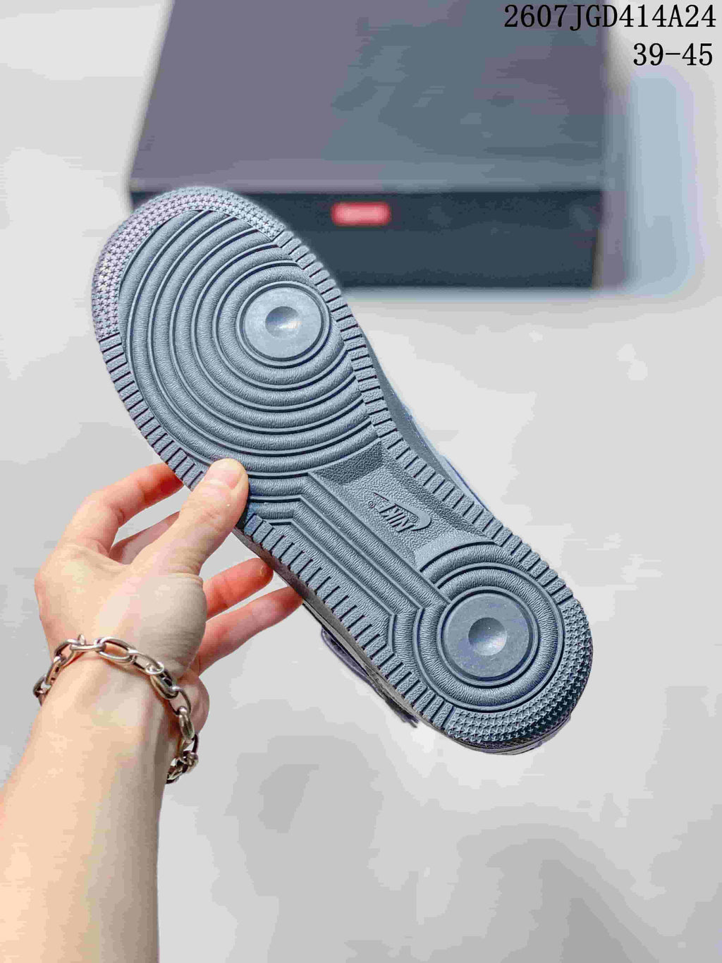 Close view of the gray textured outsole showing circular traction patterns and Air branding.