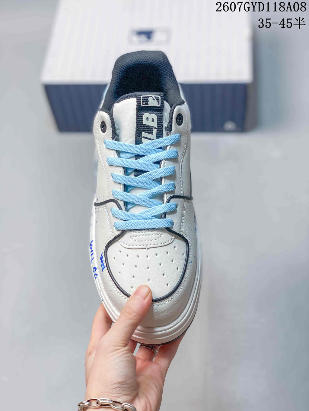 Top view of the white sneaker showing light-blue laces, a perforated toe box and dark edging.