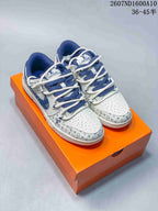 Pair of white and blue low-top sneakers with monogram-style graphics displayed on an orange presentation box.