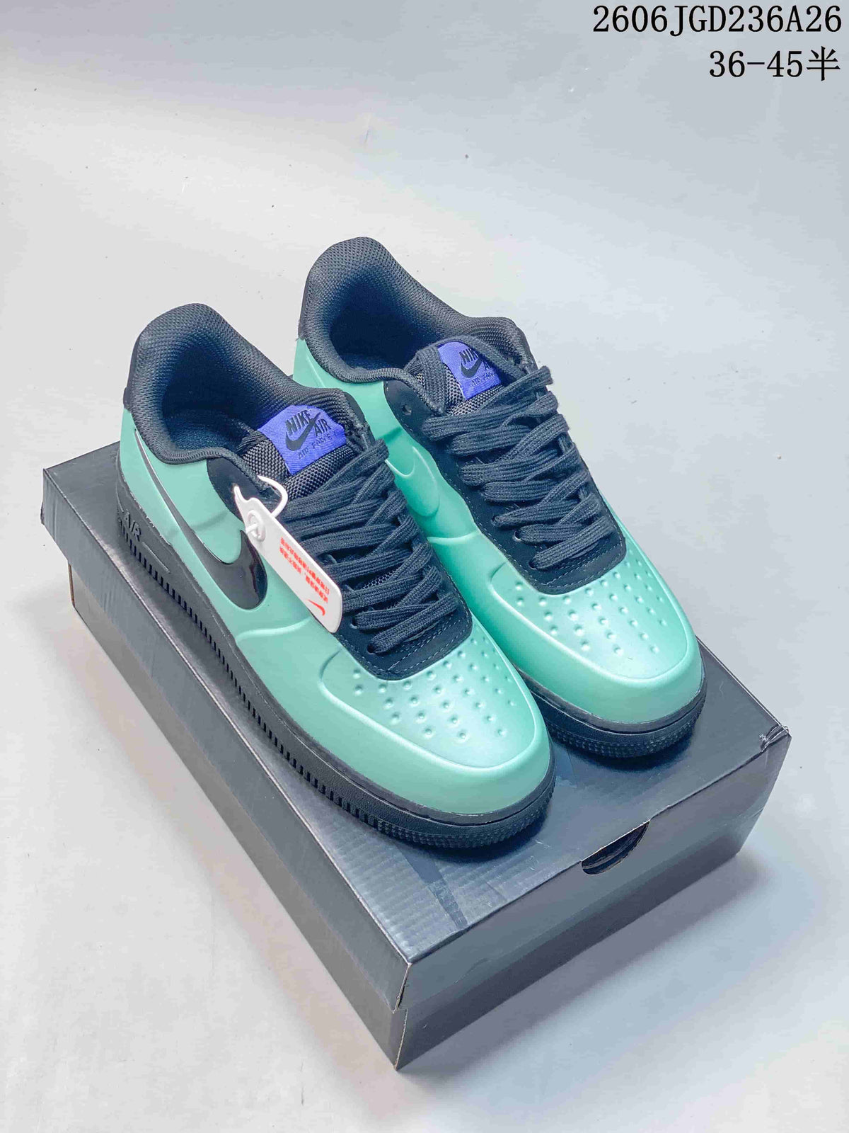 Pair of mint-green and navy Nike Air Force 1 '07 Low sneakers on a shoe box
