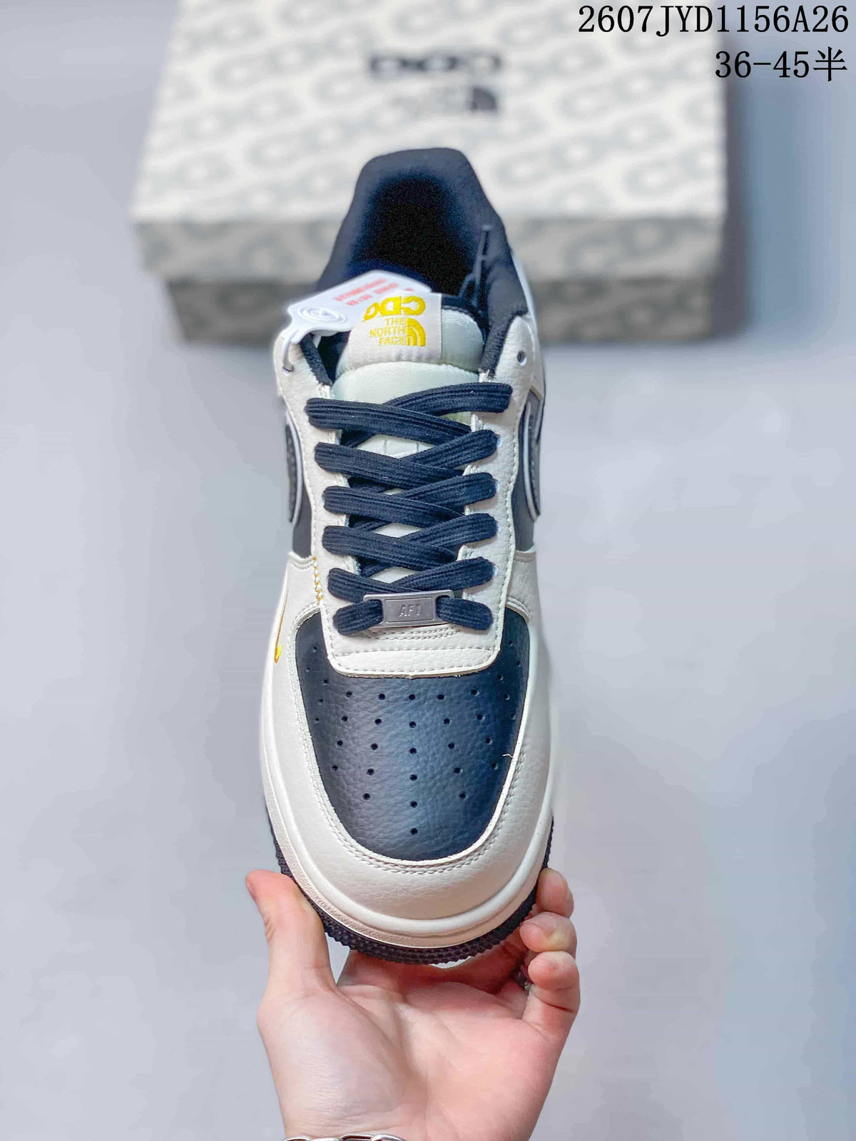 Top view of a Nike Air Force 1 sneaker showing the perforated navy toe box, white panels, dark laces, and tongue branding.