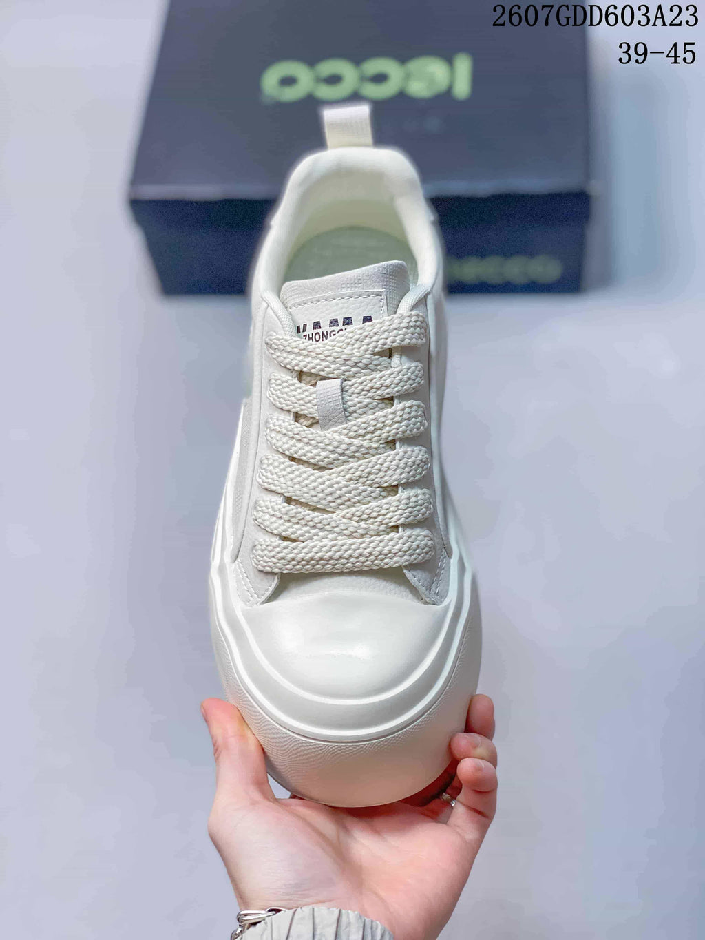 Top view of the white sneaker showing the wide woven laces, tongue branding and rounded toe.