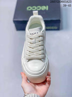Top view of the white sneaker showing the wide woven laces, tongue branding and rounded toe.