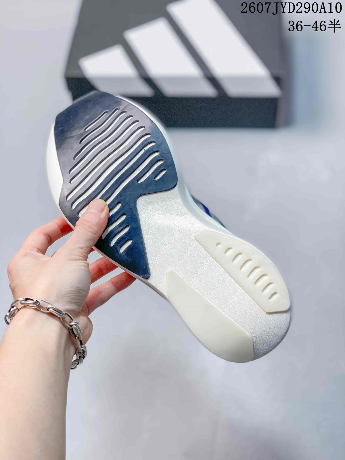 Close-up of the shoe outsole showing dark textured traction sections and white sculpted sole details.