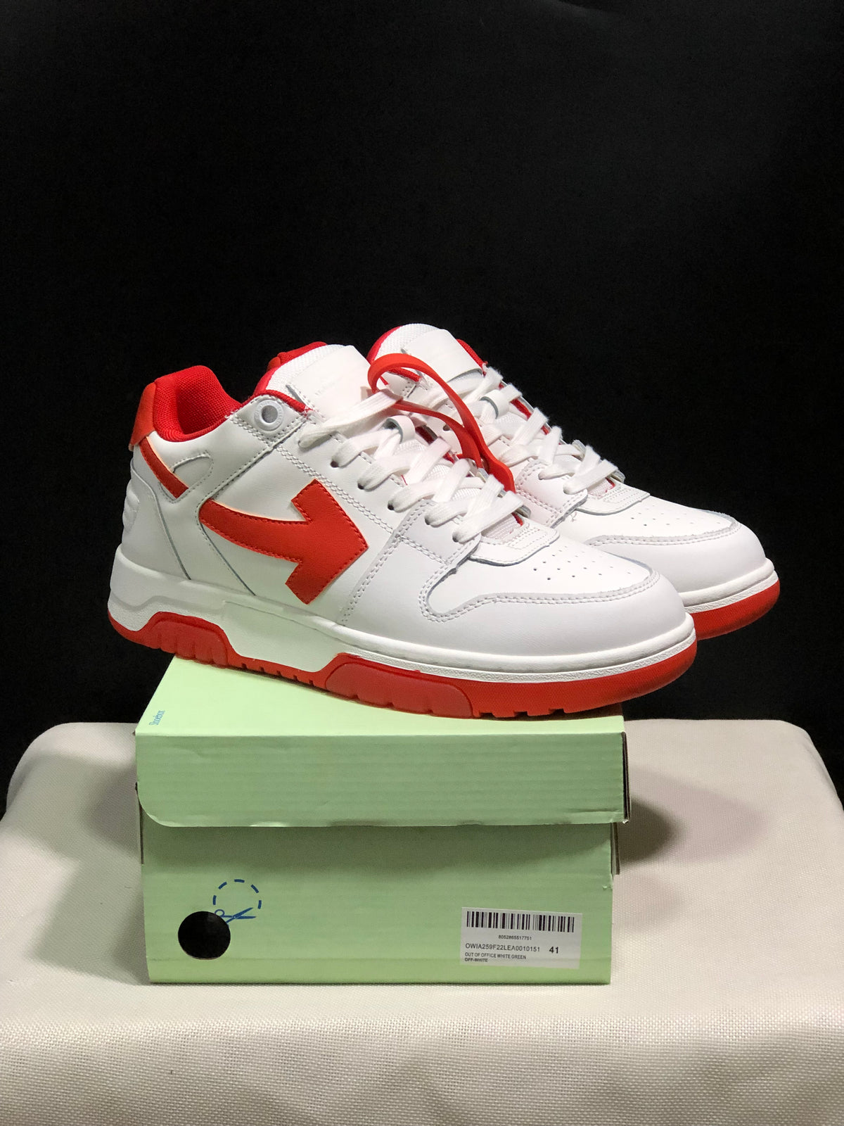 White and red Off-White Out Of Office sneakers displayed on a green shoe box, with size 41 visible on the label.