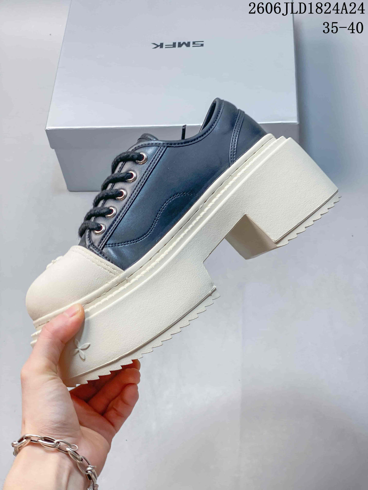 Side view of a dark lace-up sneaker with an ivory toe cap and chunky platform sole