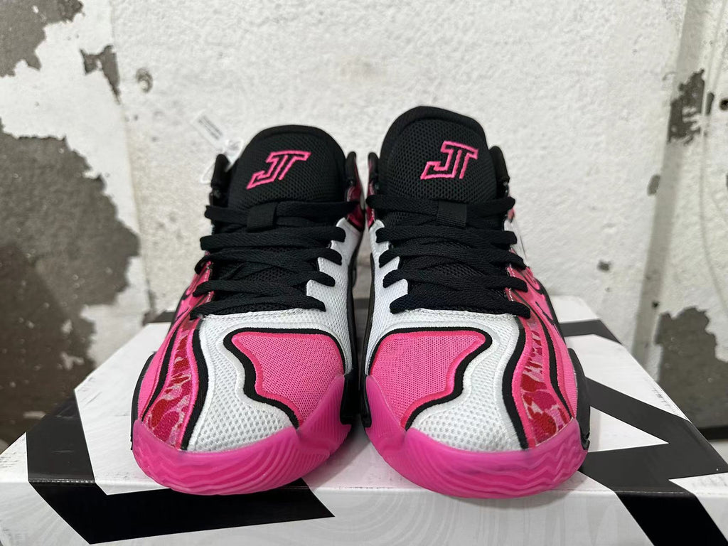Front view of black, white, and pink Jordan sneakers with black laces