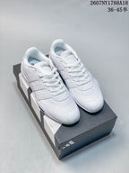 Pair of white adidas Adipista sneakers displayed on an adidas shoebox.