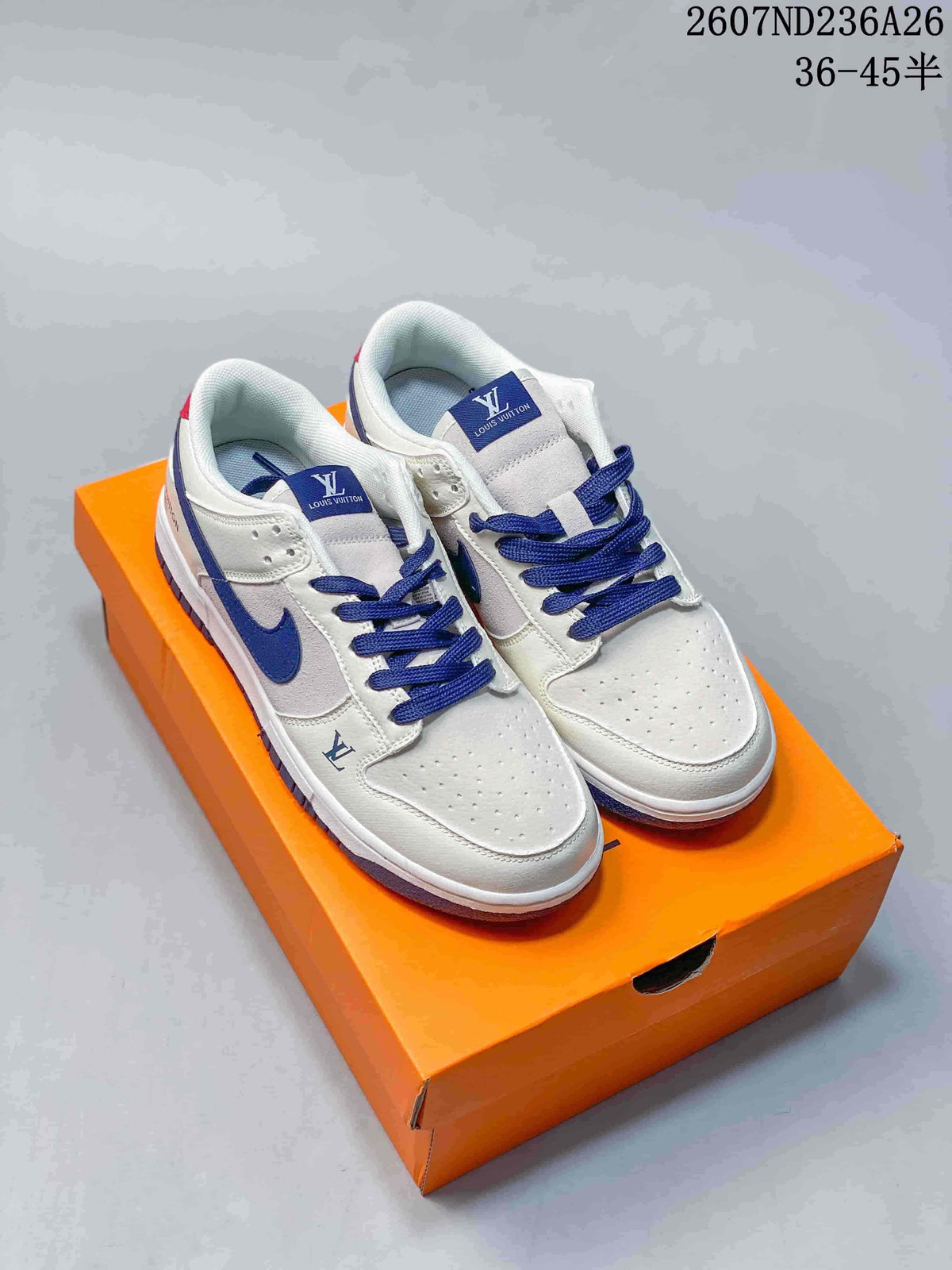 Pair of white and blue low-top sneakers displayed on an orange shoebox.