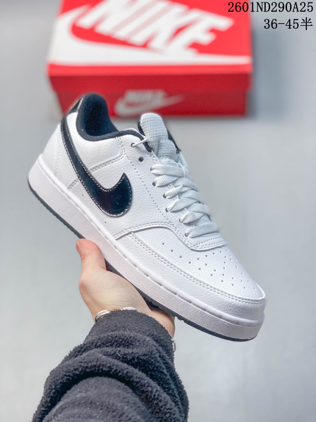 White Nike Court Vision Low sneaker with a black Swoosh, perforated toe and black outsole.
