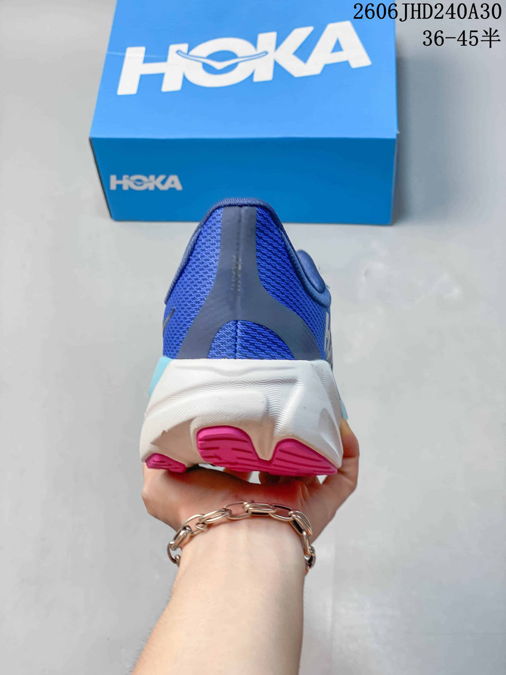 Rear view of a blue running shoe with a white midsole and pink outsole details