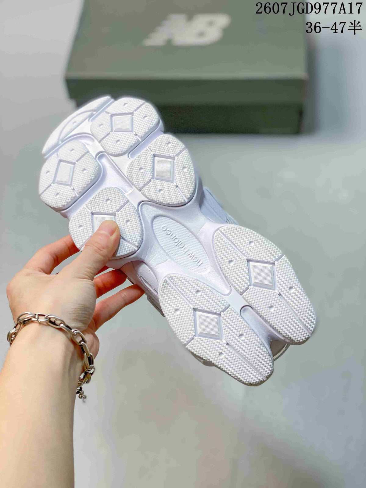 Underside view of the white sneakers showing the segmented textured outsole and ABZORB marking.