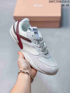 Angled side view of the white and burgundy Miu Miu sneaker showing the lace-up front, layered panels, side accent, and embossed branding near the outsole.
