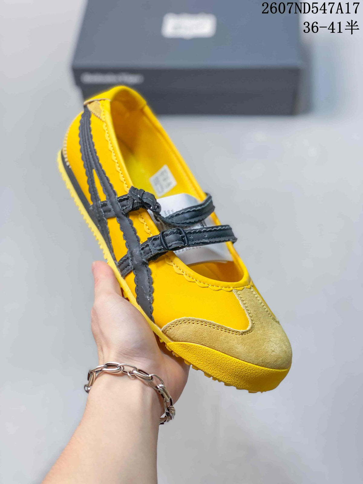 Angled front view showing the yellow and tan upper, black straps and rounded toe.