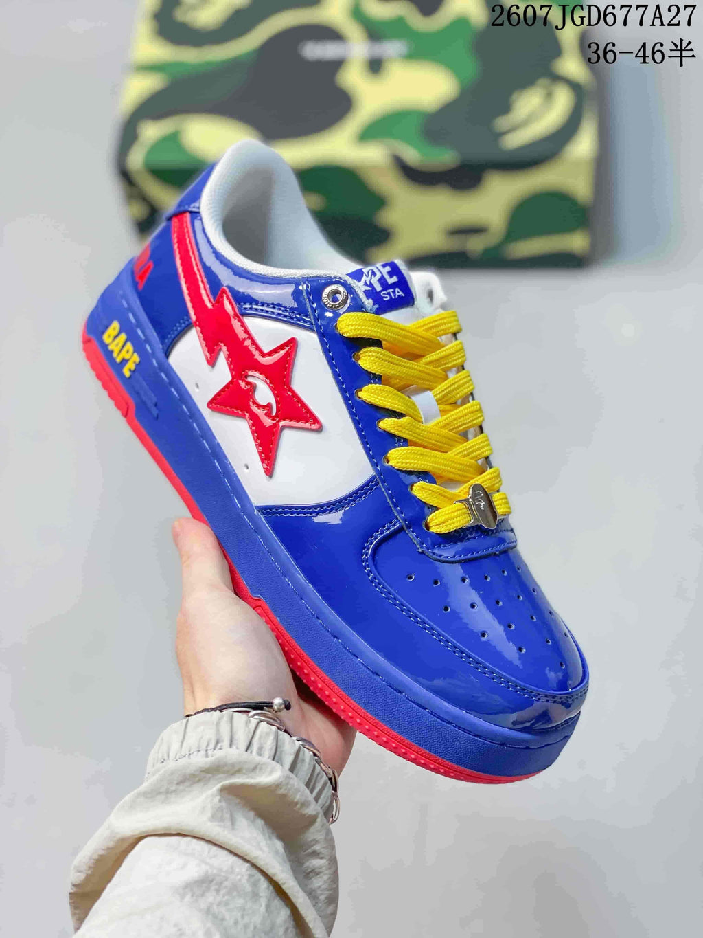Three-quarter side view of a blue BAPE Star To Low sneaker with a red star detail, yellow laces, and red outsole.
