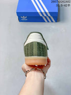 Rear view of the olive-green sneaker with textured panels and gum-colored sole