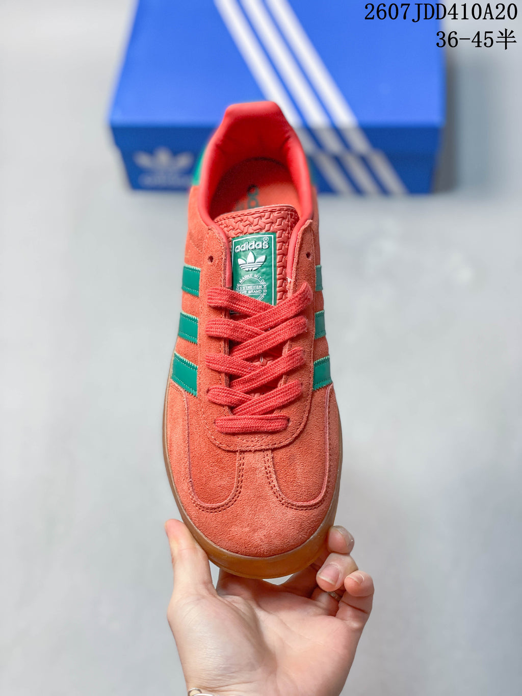 Top view showing the coral lace-up front, green side stripes and adidas tongue label.