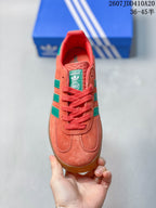 Top view showing the coral lace-up front, green side stripes and adidas tongue label.