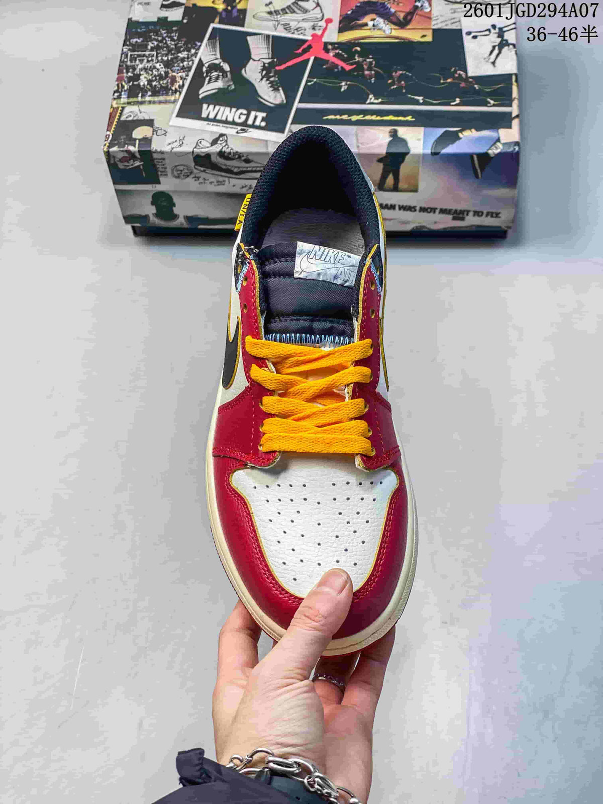 Top view showing yellow laces, black tongue and collar, red overlays, and a perforated light-colored toe box.