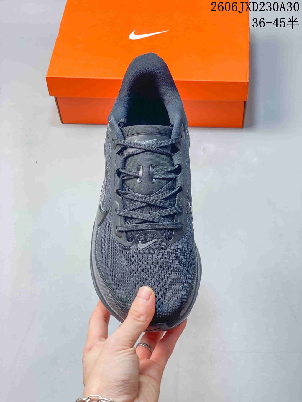 Top view of the perforated toe and lace-up front of a dark gray running shoe.
