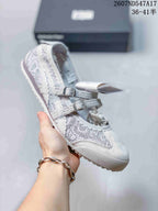 White and gray speckled Mary Jane sneaker with two buckle straps and a light outsole.