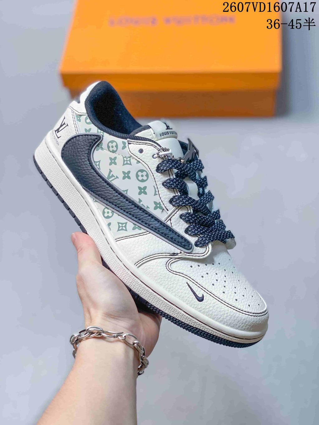 Angled side view showing the white upper, pale green monogram-style side panel, navy overlay, and dark outsole.