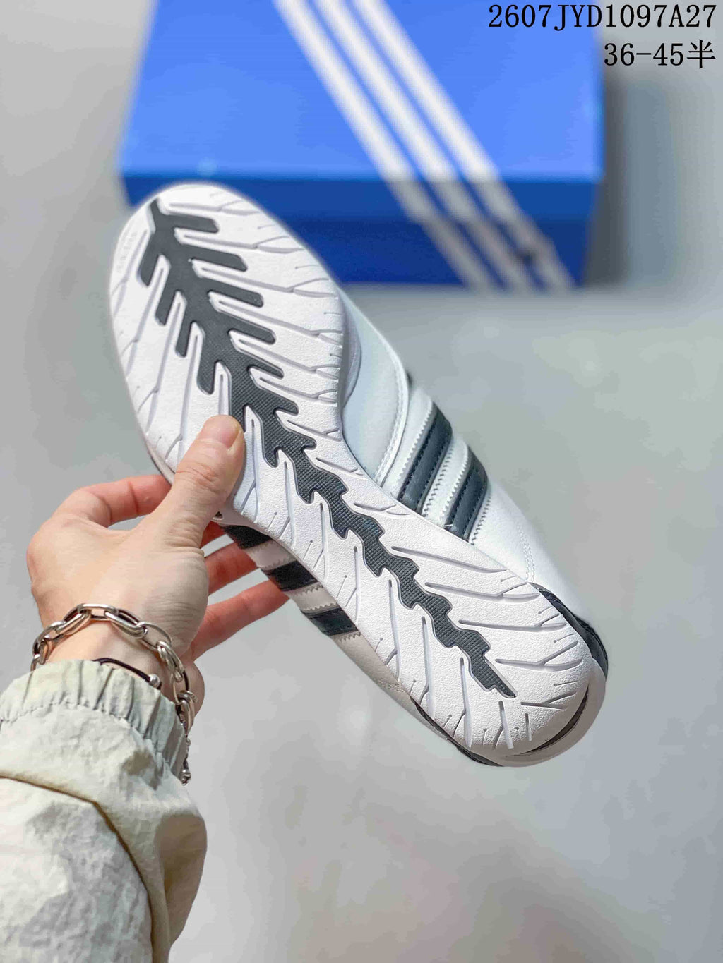Underside of the sneaker showing the white rubber outsole with dark traction detailing.