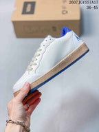 Side profile of the white low-top sneaker showing the clean side panel, perforations, gum-colored midsole, and blue outsole.