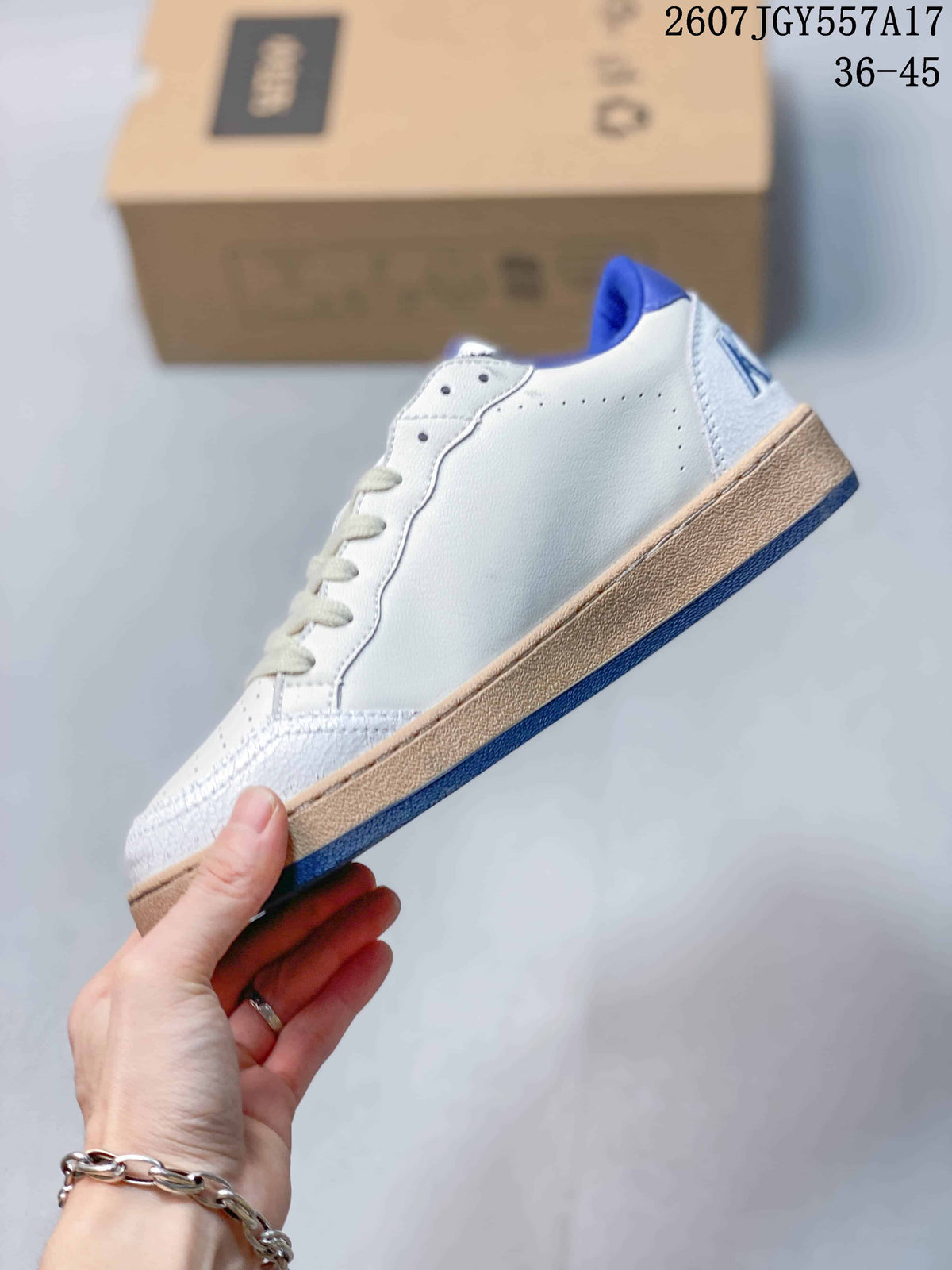 Side profile of the white low-top sneaker showing the clean side panel, perforations, gum-colored midsole, and blue outsole.