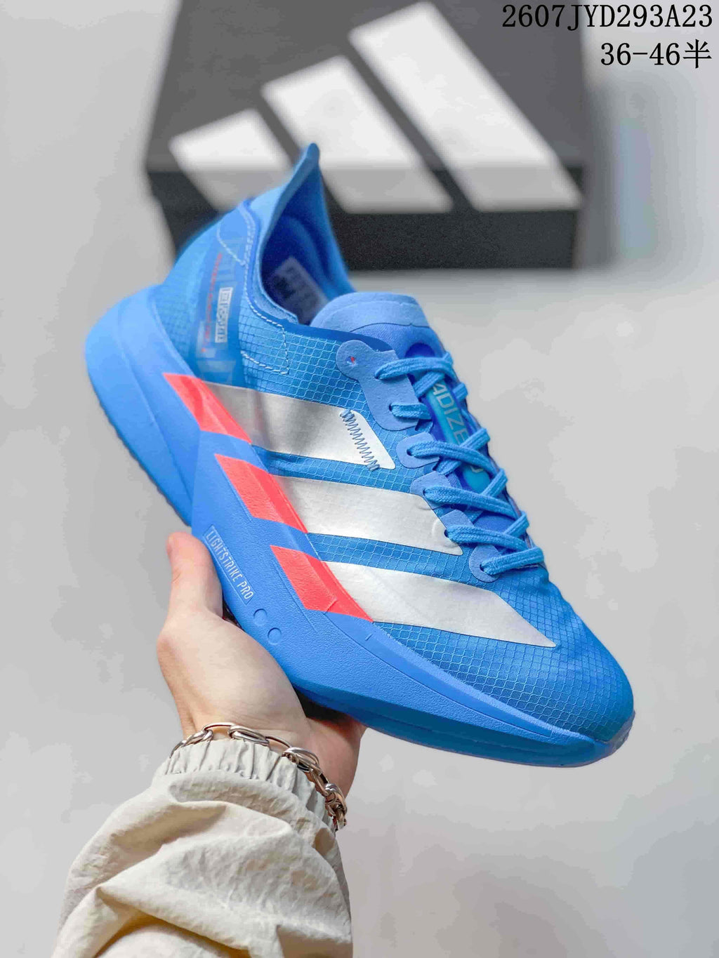 Close side view of the blue Adidas sneaker showing silver side panels, red accents and visible Lightstrike Zero branding on the midsole.