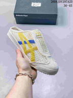 White Onitsuka Tiger Mexico 66 Sabot sneaker with yellow and blue side stripes, shown with its box; the image shows style code 2604JDY297A25 and size range 36–45.