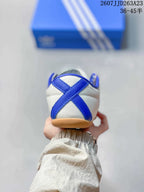 Rear view showing the blue crossed heel overlays, white upper, and gum-colored outsole.