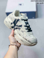 Angled close-up of the sneaker showing black side graphics, white panels, dark laces, and the sculpted sole.