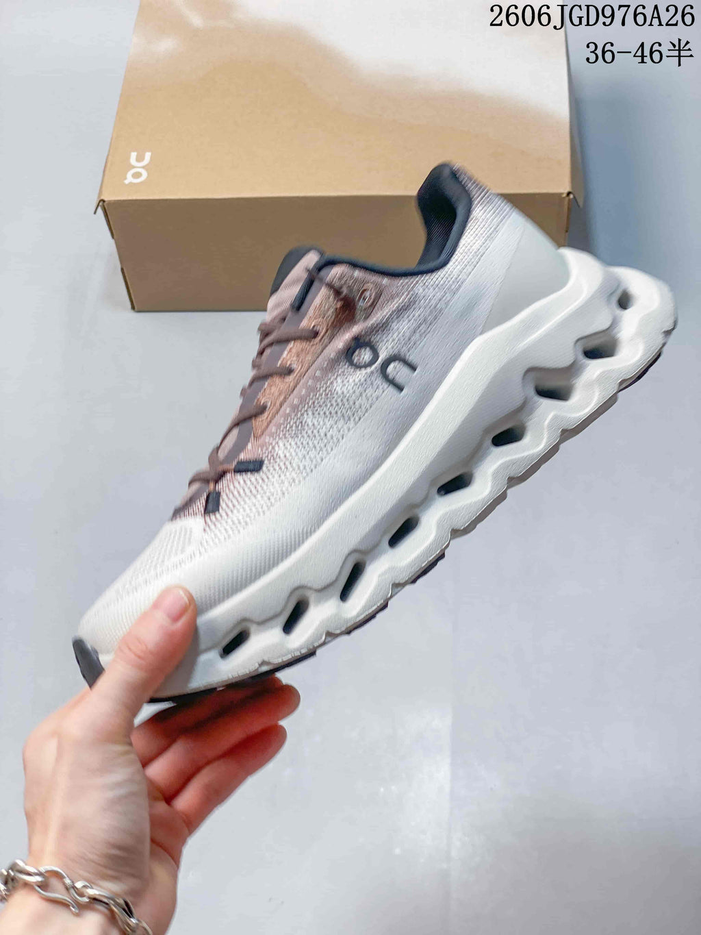 Side view of the sneaker showing the white upper, mauve details, and sculpted sole.
