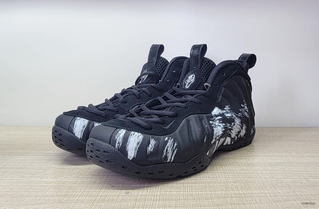Pair of black Foamposite-style high-top sneakers with white brushstroke graphics