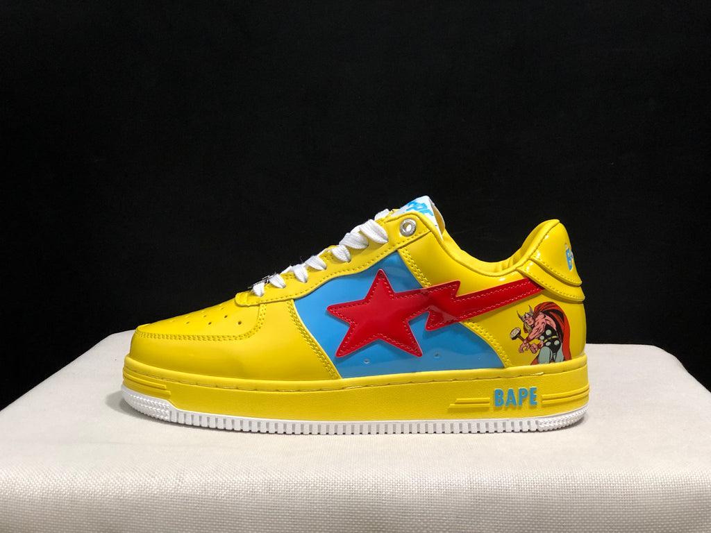 Side profile of a yellow low-top sneaker showing the blue side panel, red star graphic, heel character artwork, and white outsole.