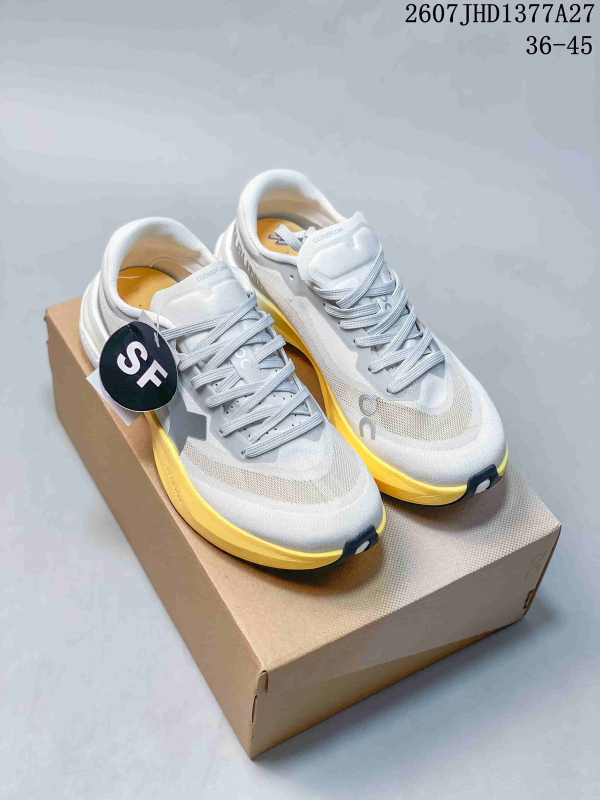 Pair of white and yellow On Cloudmonster 3 Hyper sneakers displayed on a shoebox; the image shows the printed range 36–45 and style code JHD1377A27.
