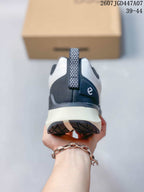 Rear view of the sneaker showing the navy heel panel, white midsole, patterned pull tab, and outsole tread.