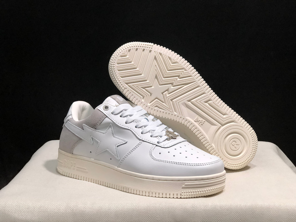 Angled view of the sneaker pair with one shoe lifted to reveal the patterned rubber outsole.
