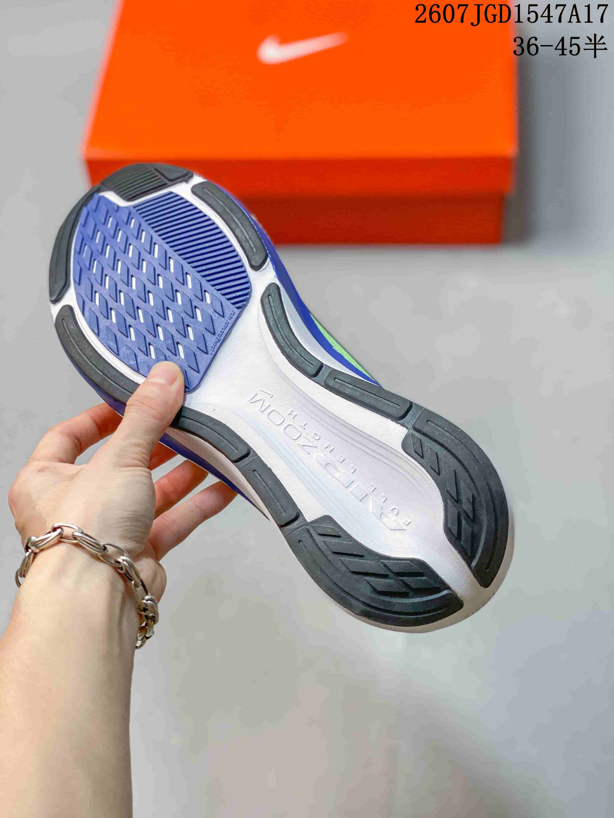 Underside view of the sneaker showing a segmented blue, white, and black rubber outsole.