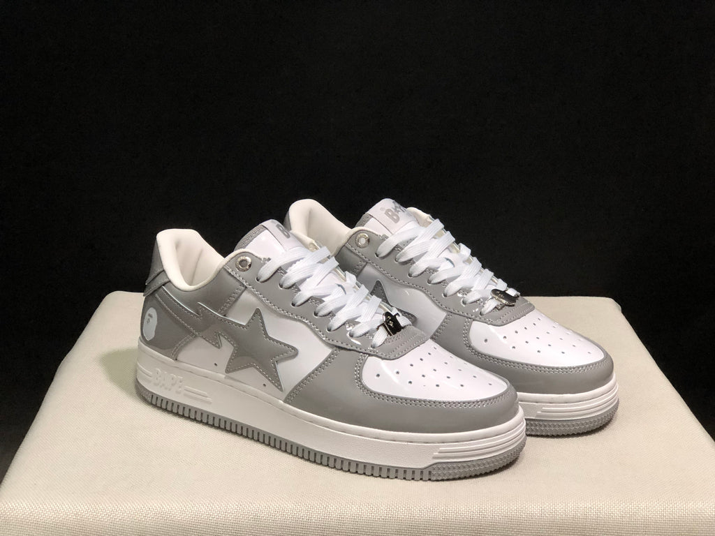 Front angled view of the white and grey pair with star side panels and perforated toe boxes.
