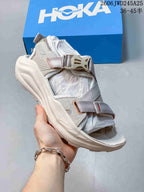 Light gray HOKA Infini Hike TC sandal with adjustable straps and contrasting accents